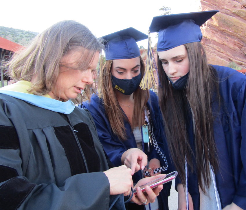 EHS science teacher Ann Thomas helps Kylie Jones and Claire Niemet figure out their places in line before the graduation ceremony at Red Rocks Amphitheatre.